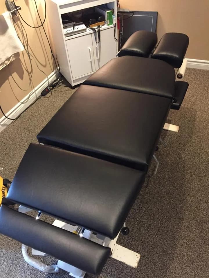 Chiropractic table upholstered with commercial black vinyl